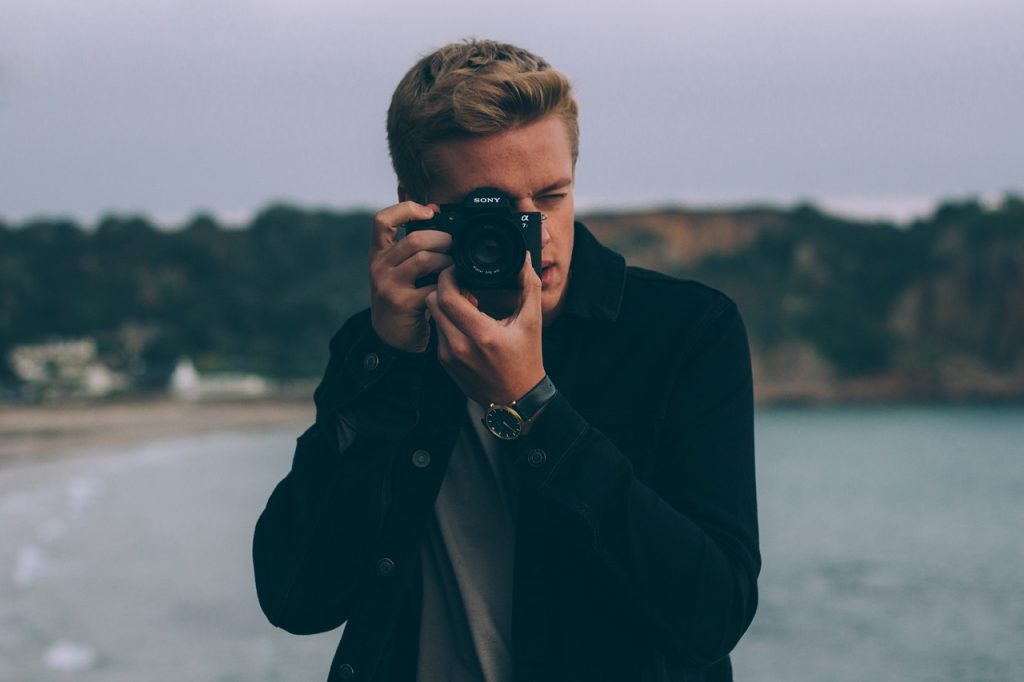 Photographer taking a photo near the ocean.