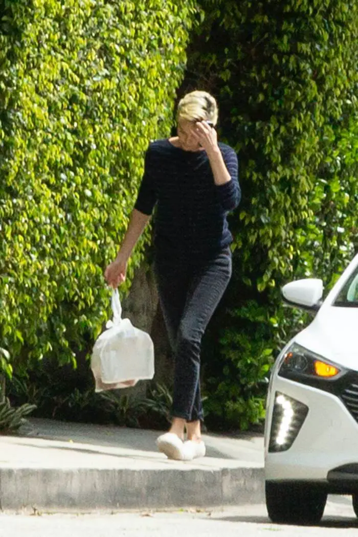charlize theron outside her home grabbing a food delivery 4