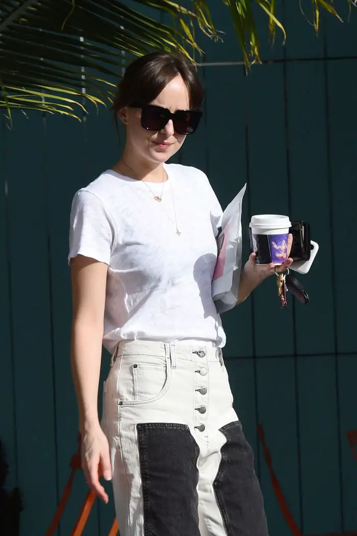 Dakota Johnson in Denim Jeans with Black Panels on the Legs as she Goes for a Coffee