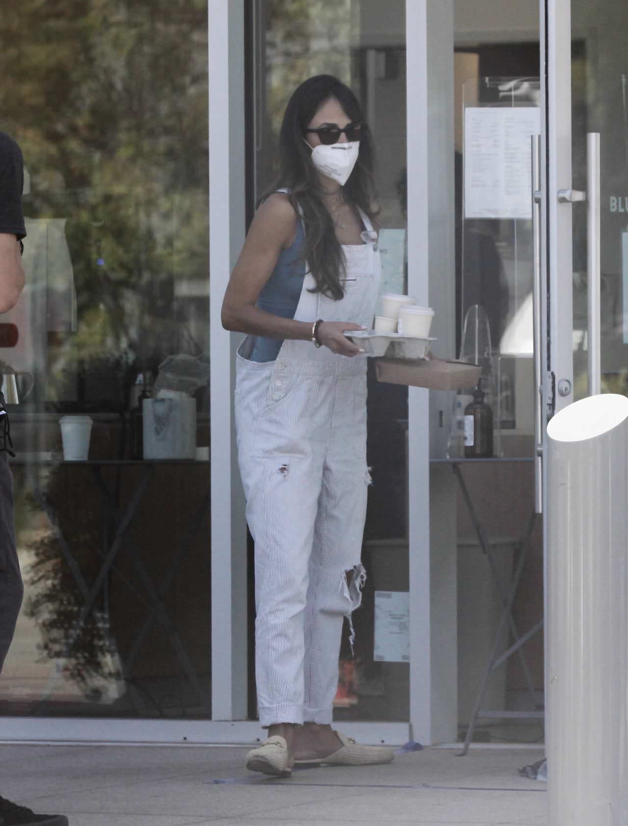 jordana brewster does a coffee run in distressed white overalls 2