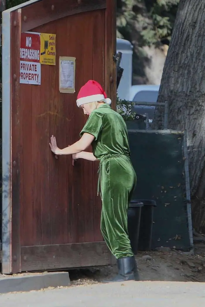 kristen bell dressed for the holidays in green overalls and a santa hat in la 1
