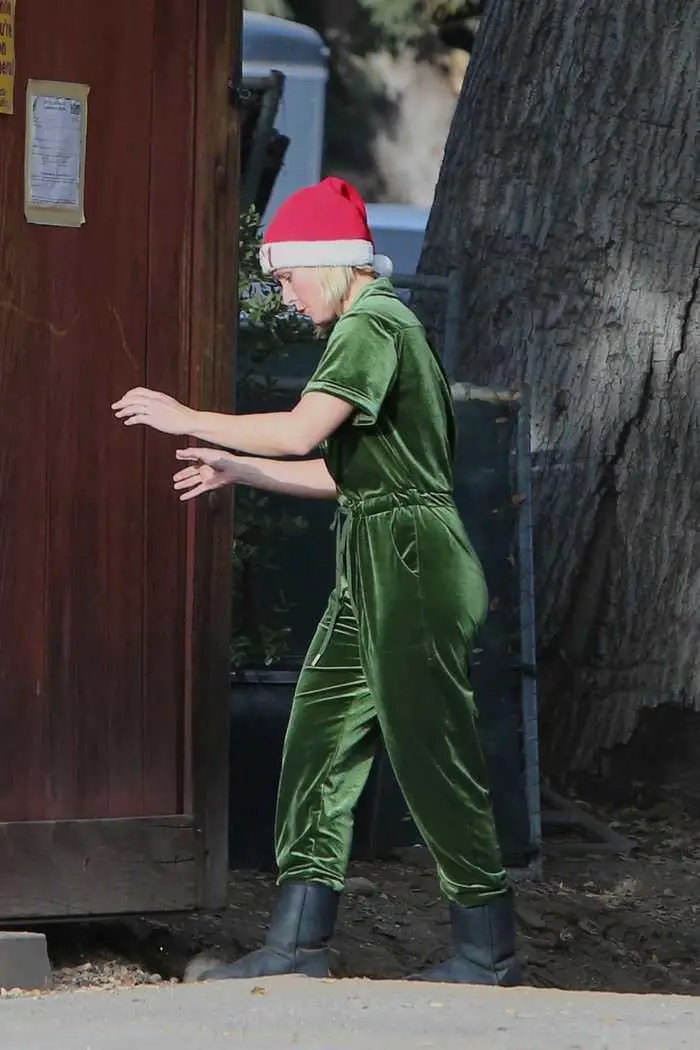 kristen bell dressed for the holidays in green overalls and a santa hat in la 3