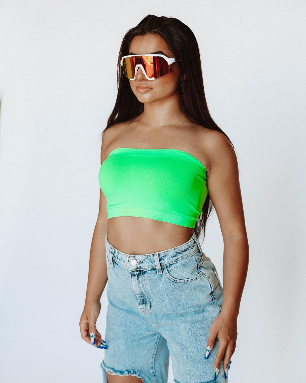 tati mcquay posing in green strapless top and jeans 3