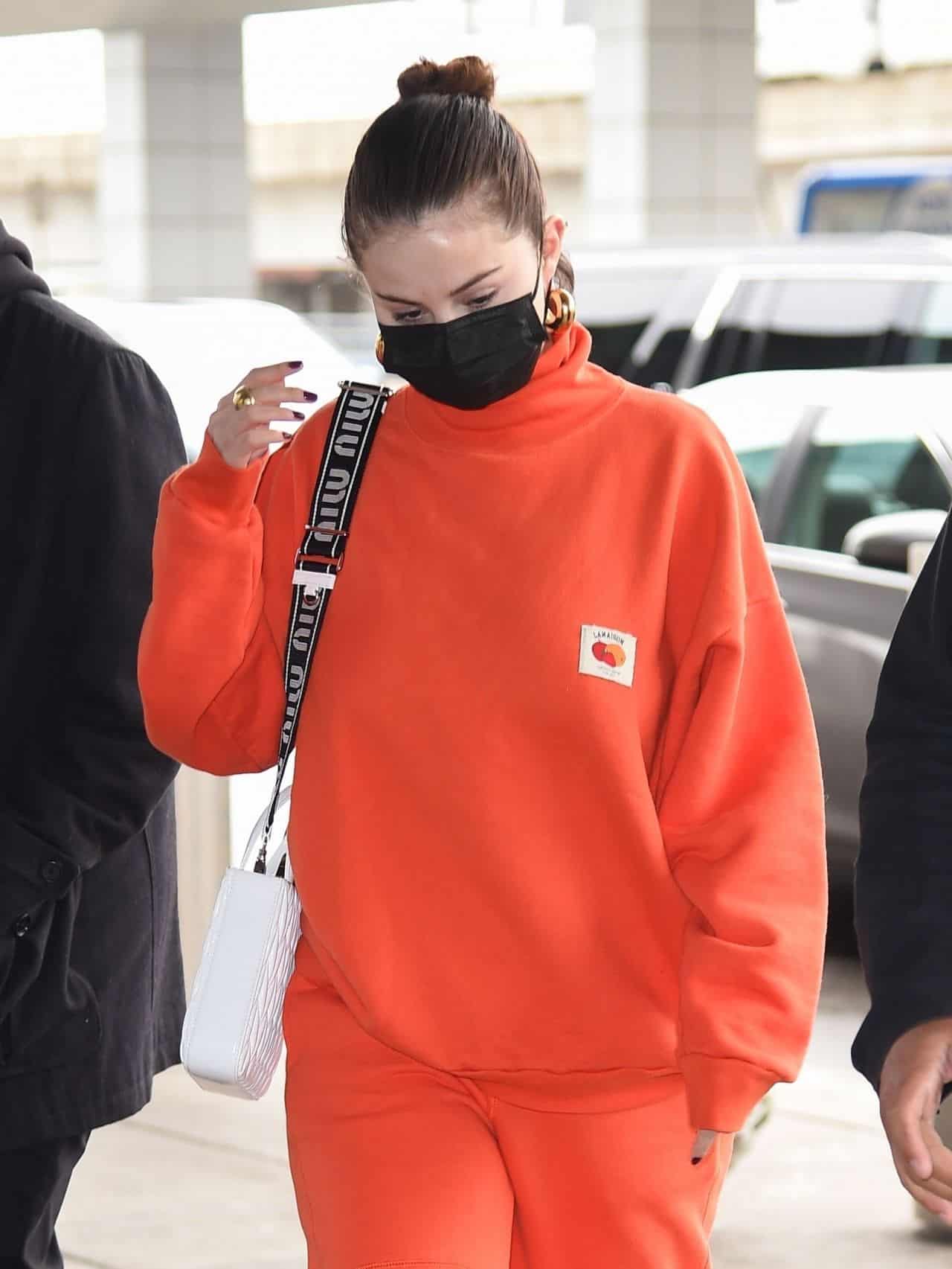 Selena Gomez Arrives at JFK Airport in an All-Orange Casual Outfit