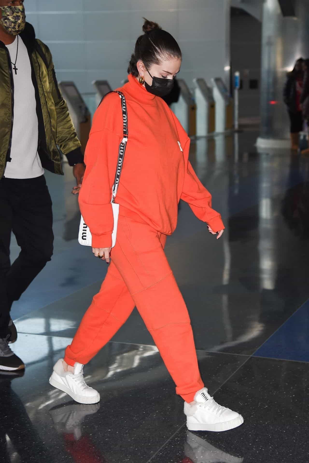 Selena Gomez Arrives at JFK Airport in an All-Orange Casual Outfit