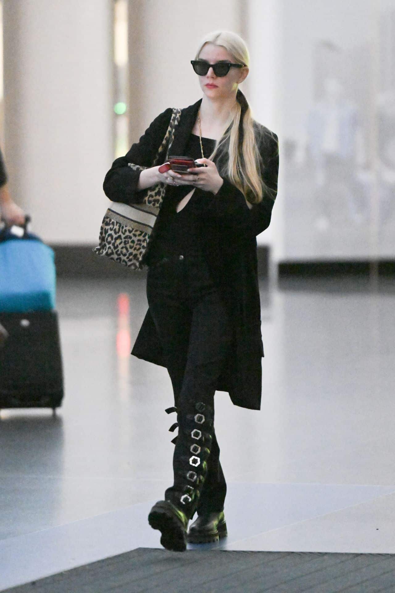Anya Taylor-Joy is Chic in a Black Coat and Knee-high Boots at JFK Airport