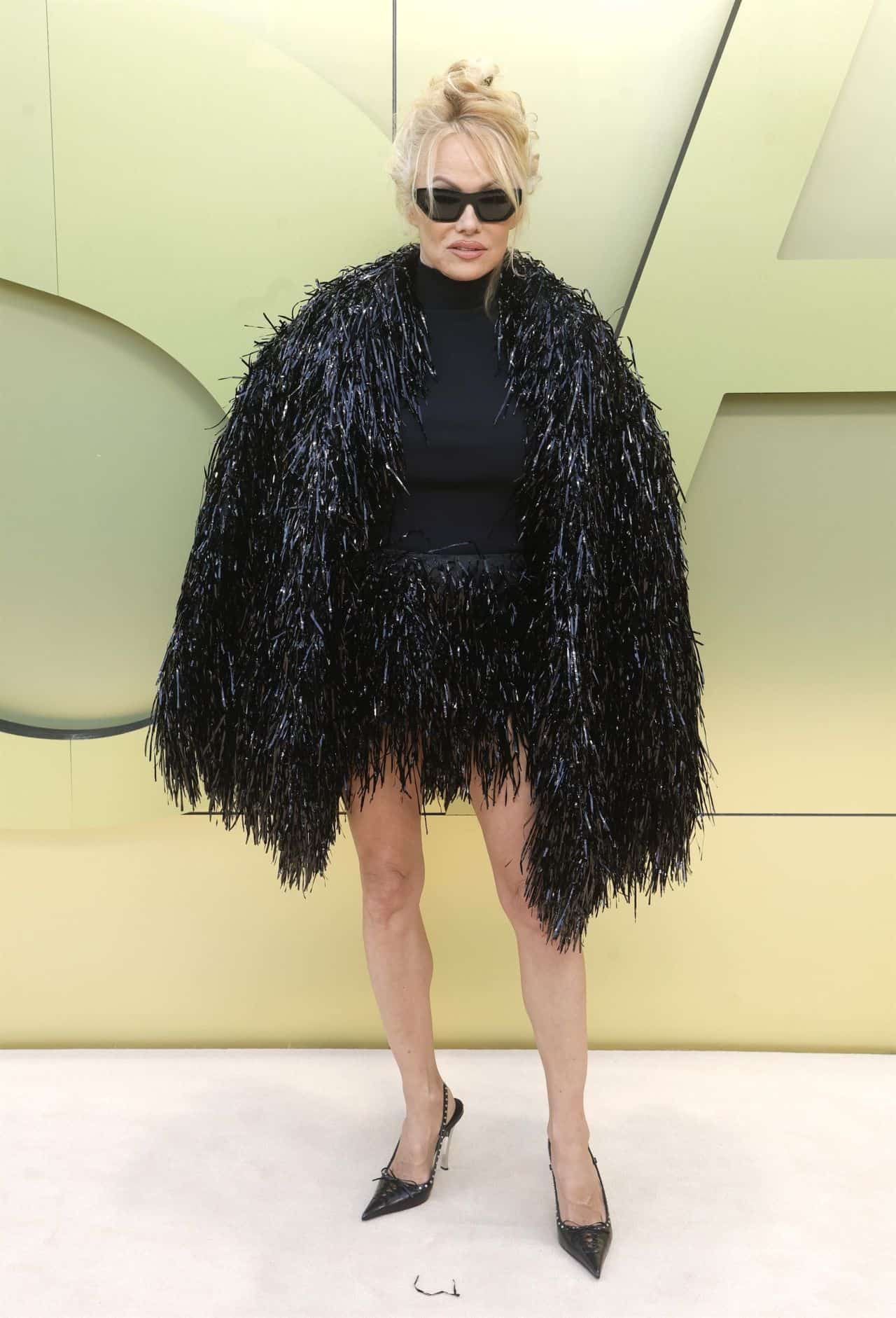 Pamela Anderson Stuns in a Black Fringe Coat at Versace's Fall 2023 Show
