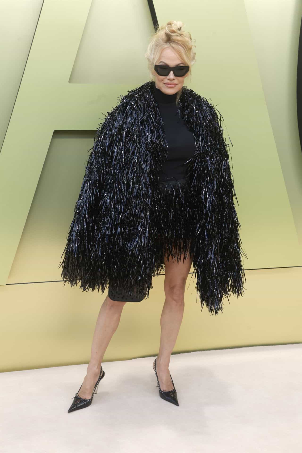 Pamela Anderson Stuns in a Black Fringe Coat at Versace's Fall 2023 Show