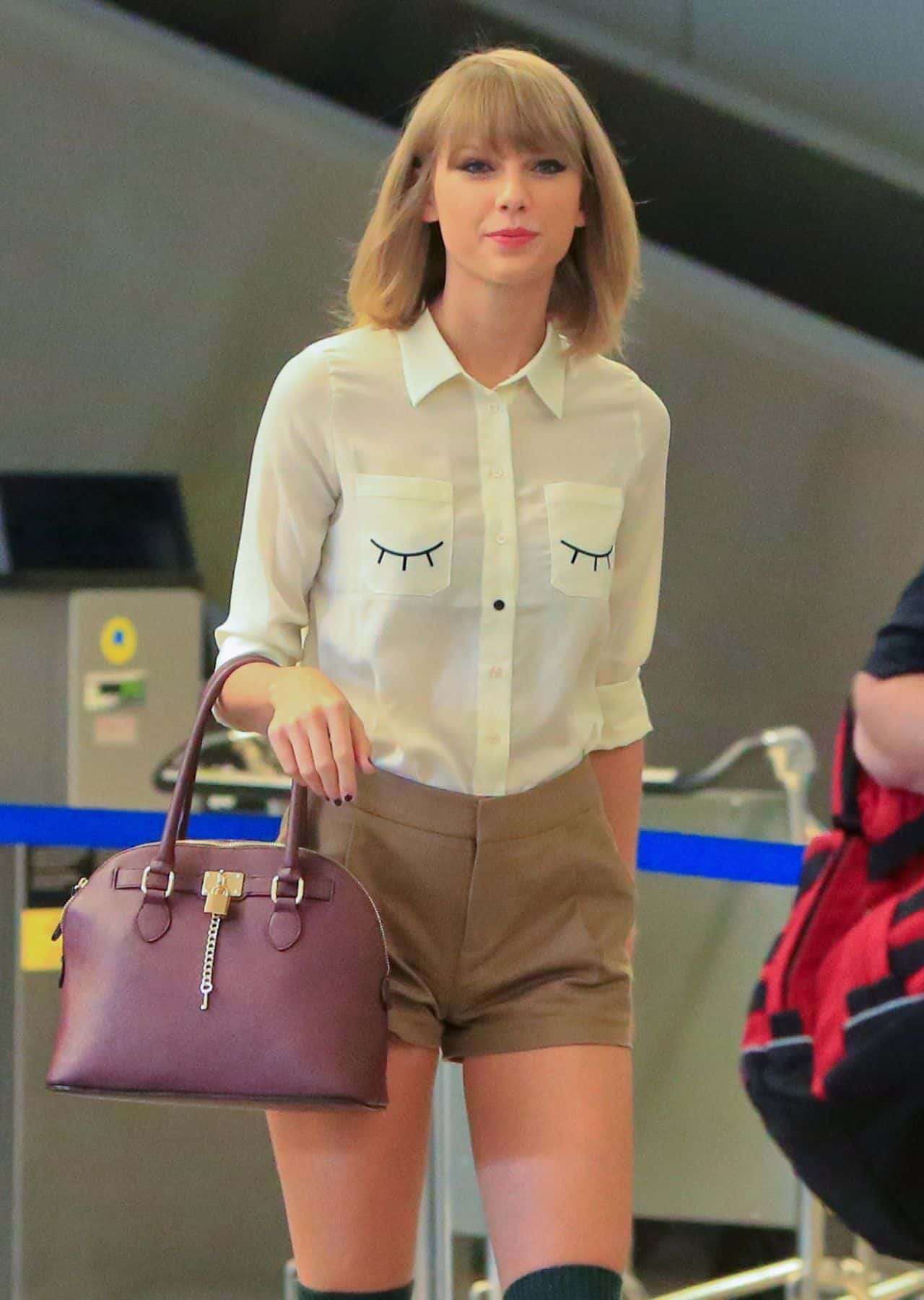 Taylor Swift Wears Brown Shorts and a White Shirt at LAX Airport