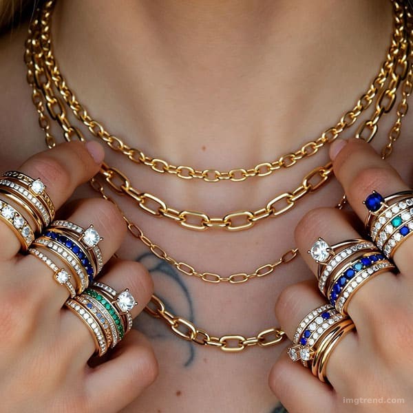 Close-up illustration of layered gold necklaces, rings, and tattoos on a figure resembling Halsey